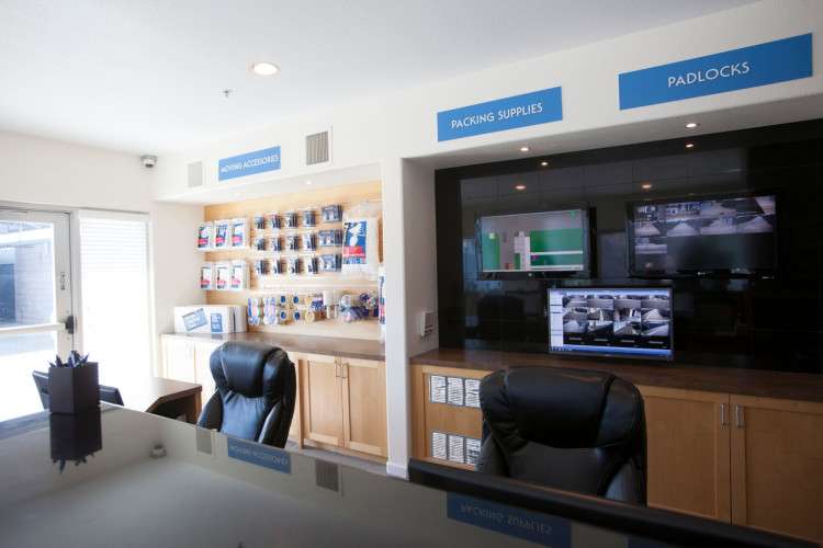 front desk in office with leather chairs and security monitors