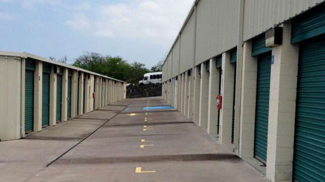 outdoor aisle of storage facility with blue roll-up doors