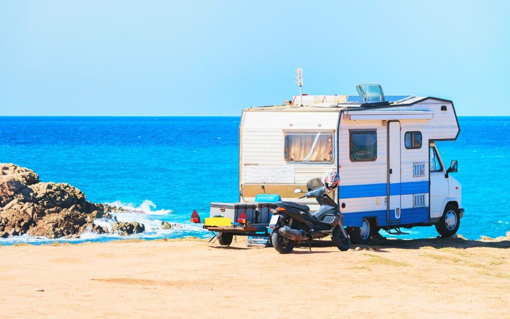 A camper van overlooking the ocean from a cliffside vantage point. 