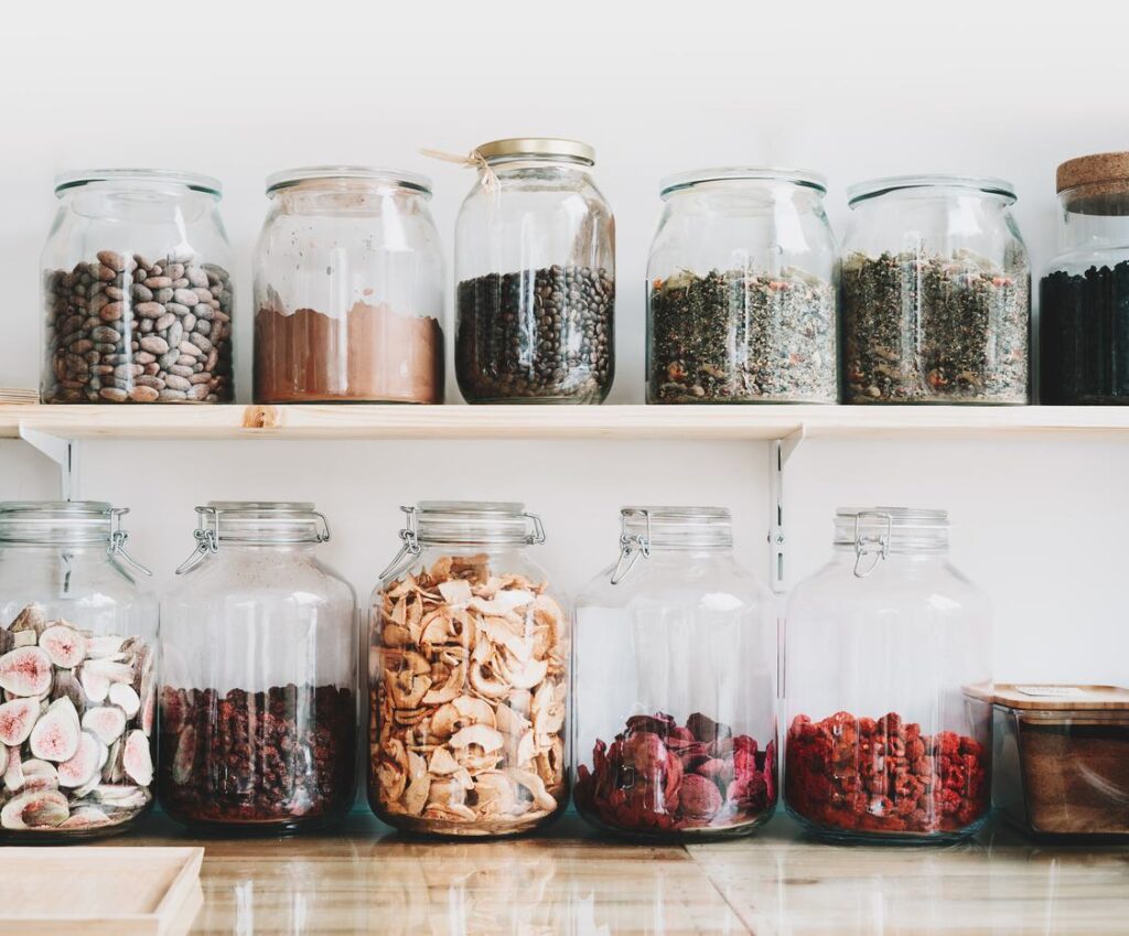 Clear, glass storage containers neatly lined up in two rows near the kitchen counter. 